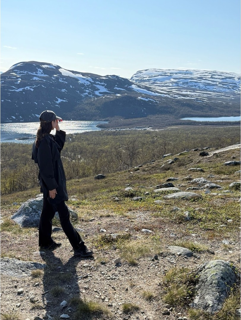 Vastuullisuuskonsultti Salla Neuman kesälomalla Saana-tunturilla kiikaroimassa Malla-tuntureita.